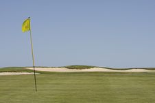 Green Golf Field Showing A Yellow Flag Royalty Free Stock Image