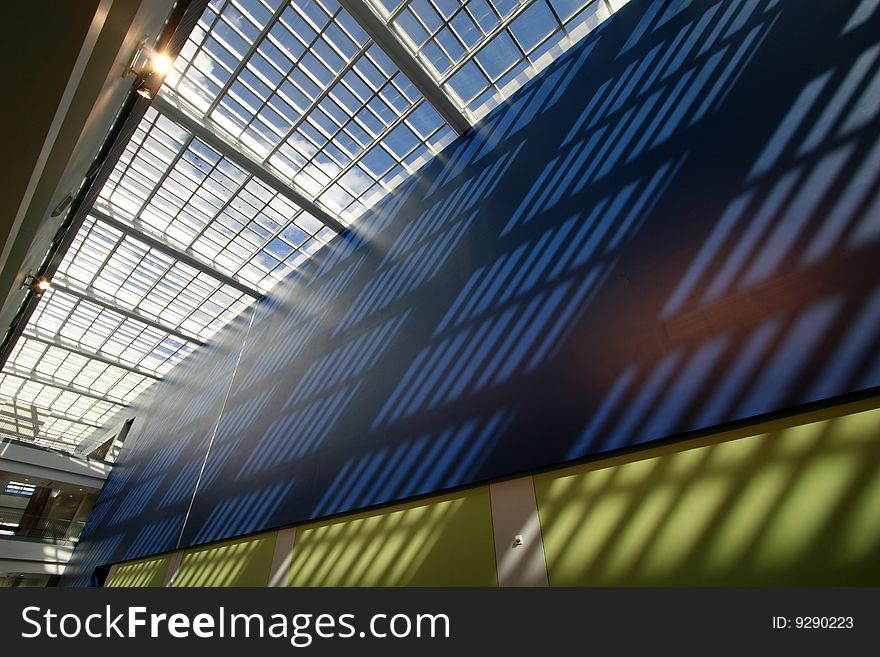 Glass roof shadowing and allowing for exterior light to wash the marble floor with a pattern. Glass roof shadowing and allowing for exterior light to wash the marble floor with a pattern