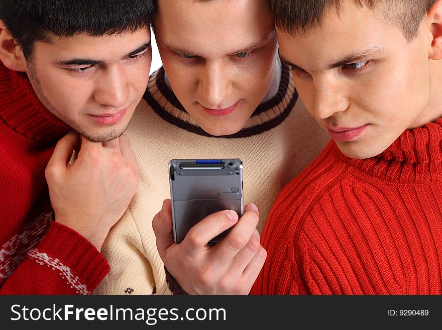 Three young friends look on handheld computer