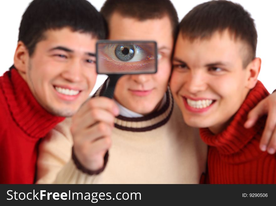 Three friends look through magnifier on white