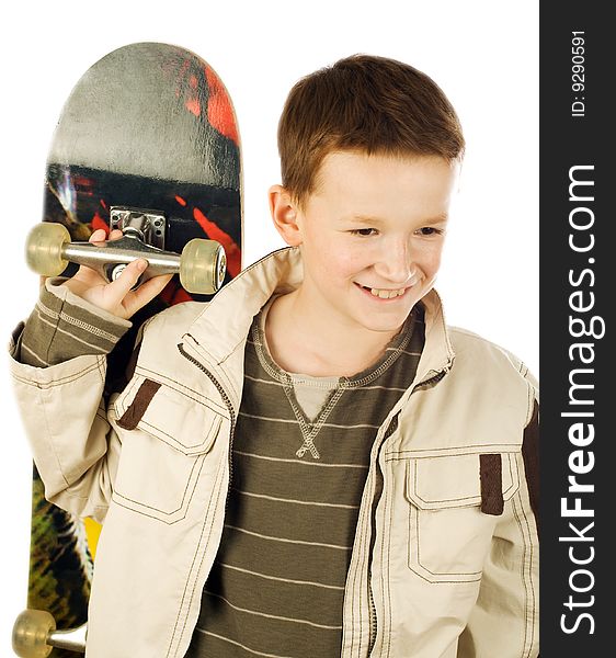 Smiling young boy holding skateboard on back