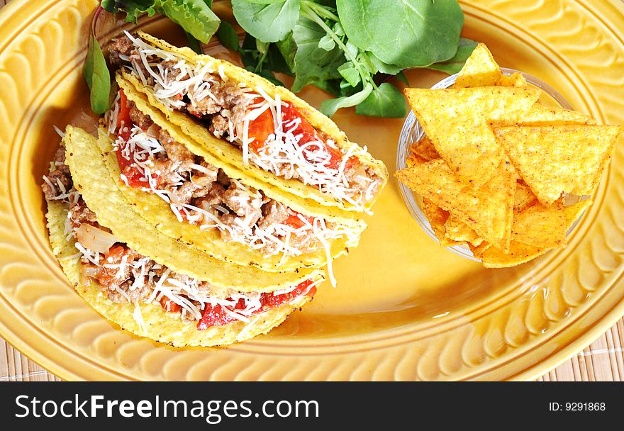 Tacos filled with minced meat peppers and cheese - salad on side. Tacos filled with minced meat peppers and cheese - salad on side
