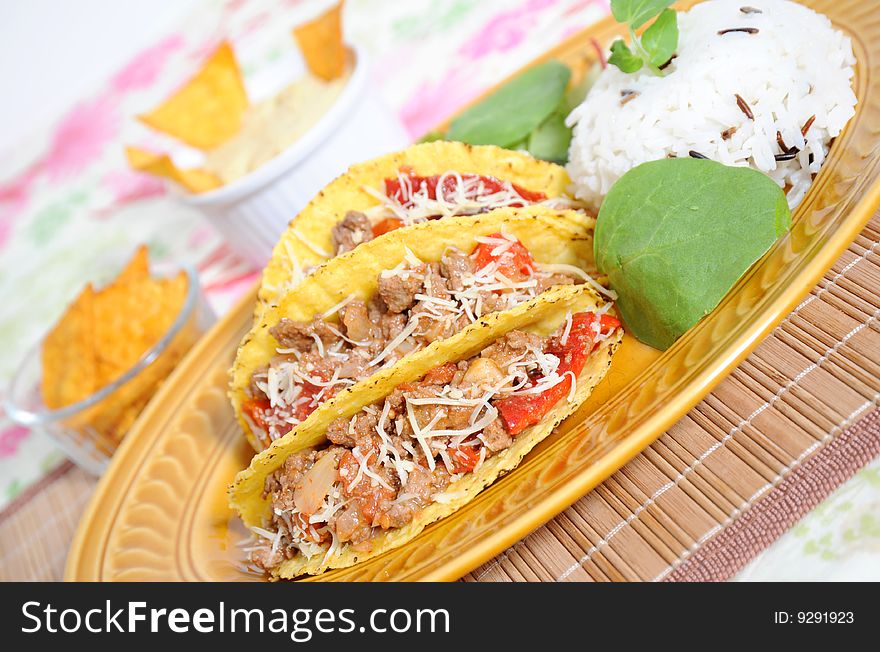 Tacos filled with minced meat peppers and cheese  - rice  on side. Tacos filled with minced meat peppers and cheese  - rice  on side