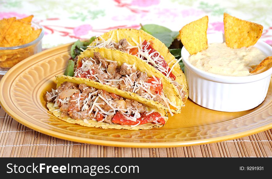 Tacos filled with minced meat peppers and cheese  - guacamole sauce on side. Tacos filled with minced meat peppers and cheese  - guacamole sauce on side