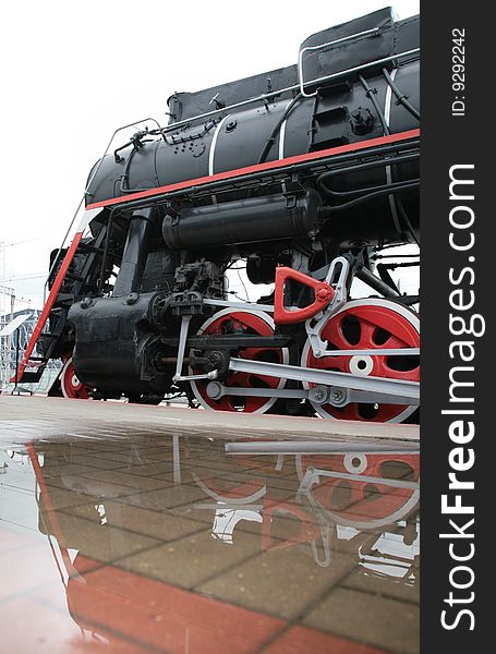 Steam locomotive and its reflection in puddle