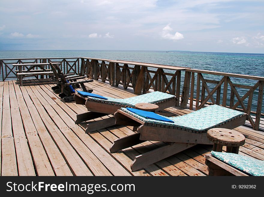 Several wooden tanning benches by the ocean