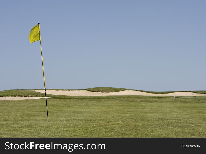 Amazing green golf field showing the hole and the flag shadow, without ball. Amazing green golf field showing the hole and the flag shadow, without ball