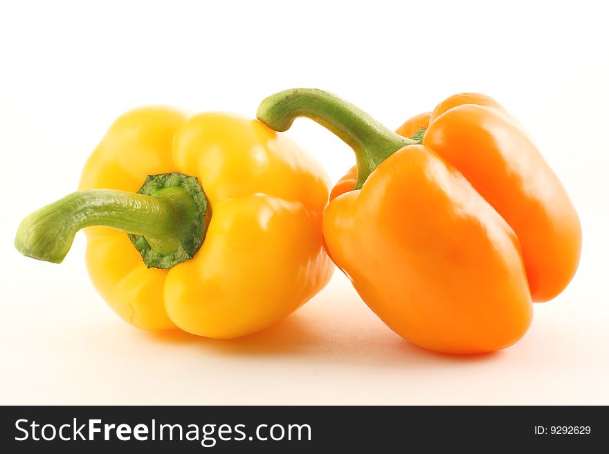 Two paprika peppers with one leaning on the other. Two paprika peppers with one leaning on the other