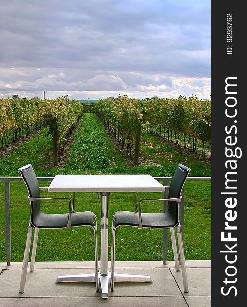An empty table for two on a patio overlooking a vineyard. An empty table for two on a patio overlooking a vineyard