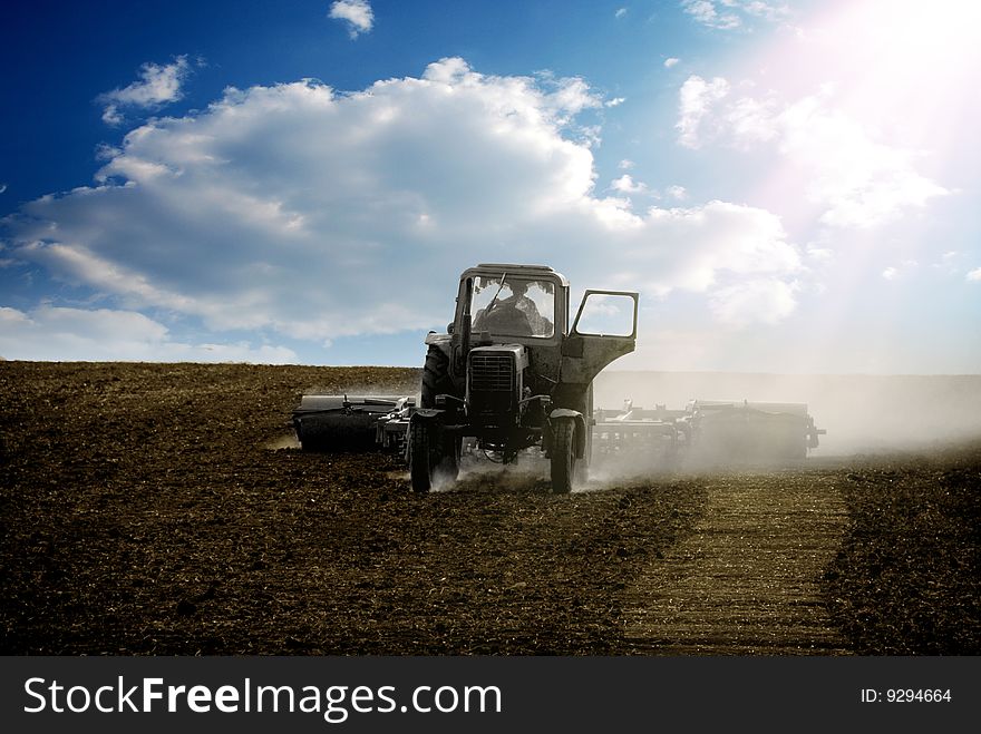 The tractor ploughs a field in the springtime