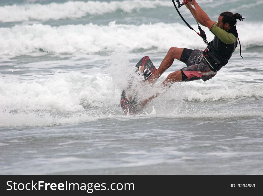 Kitesurfer surfing through the waves