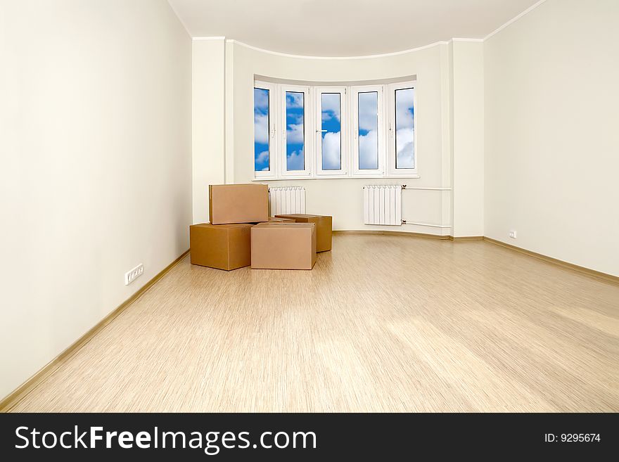 Interior of an empty room with the packed boxes, shined with a sunlight. Interior of an empty room with the packed boxes, shined with a sunlight