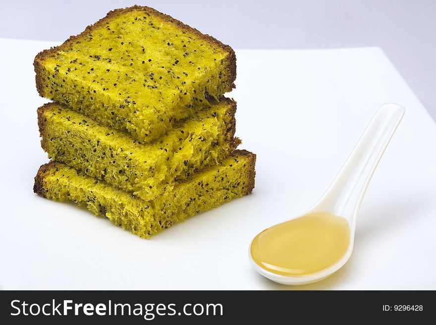 Citrus cake with poppy-seeds and honey on white background