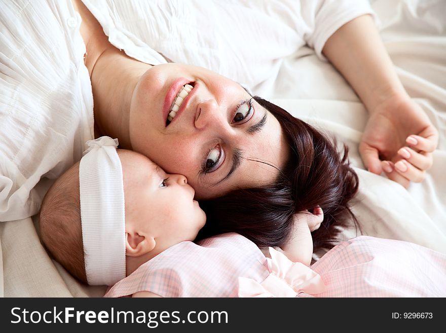 Happy mother lying with her newborn daughter. Happy mother lying with her newborn daughter