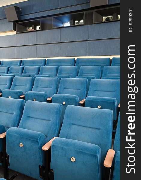 Close-up of empty cinema auditorium with line of blue chairs. Close-up of empty cinema auditorium with line of blue chairs.