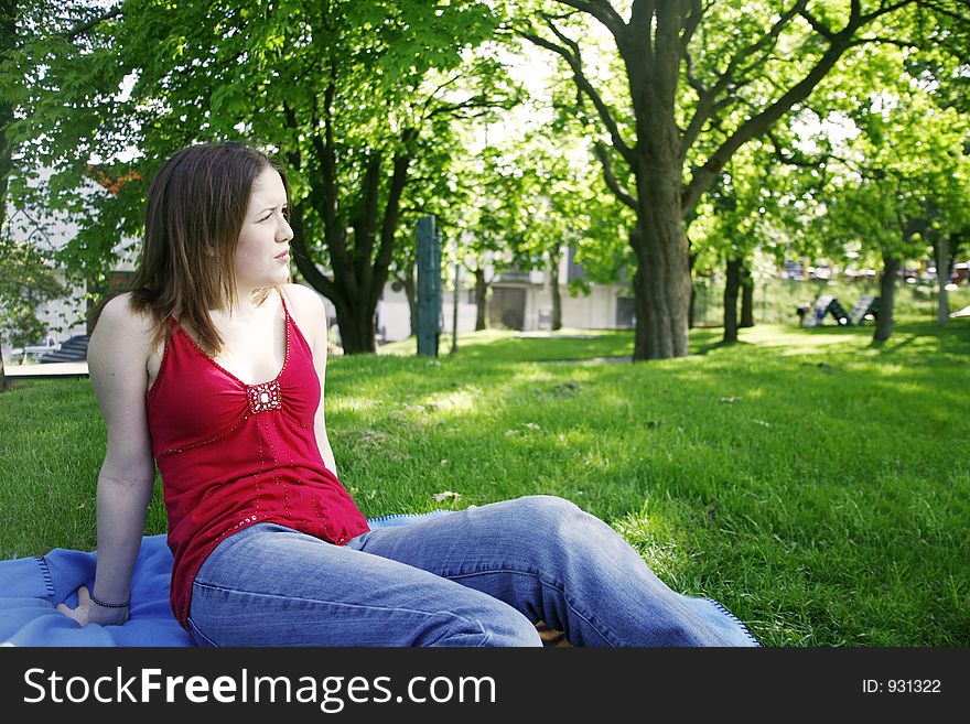 Young woman sitting in a park. Young woman sitting in a park