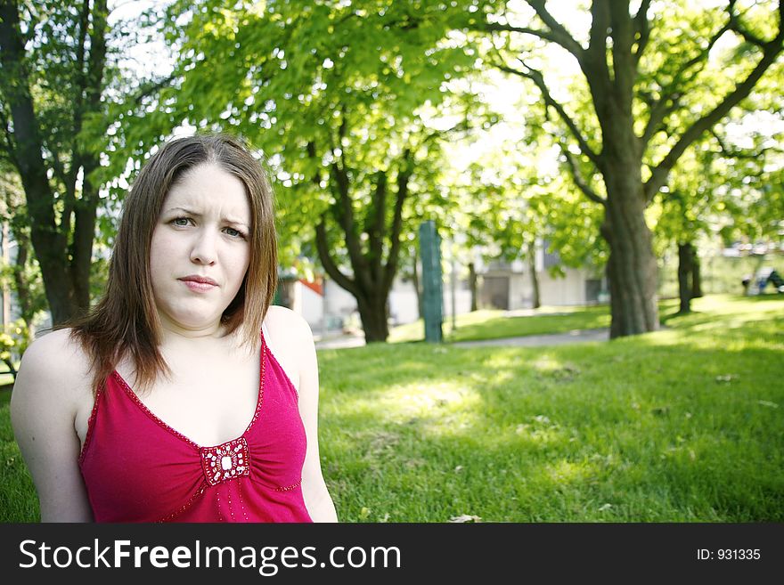 Woman in park with odd look on her face. Woman in park with odd look on her face