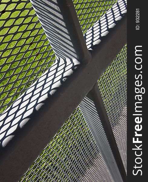 The intersection of vertical and horizontal supports for a screen fence is made cruciform by the perspective and cropping. The intersection of vertical and horizontal supports for a screen fence is made cruciform by the perspective and cropping.