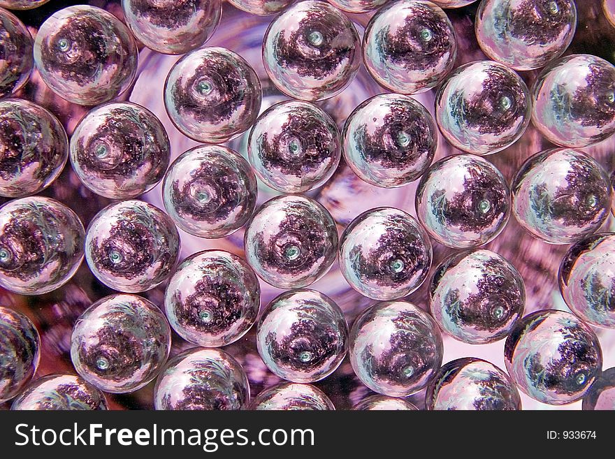 Some clear glass marbles reflecting color and the overhead trees in this background image. Some clear glass marbles reflecting color and the overhead trees in this background image