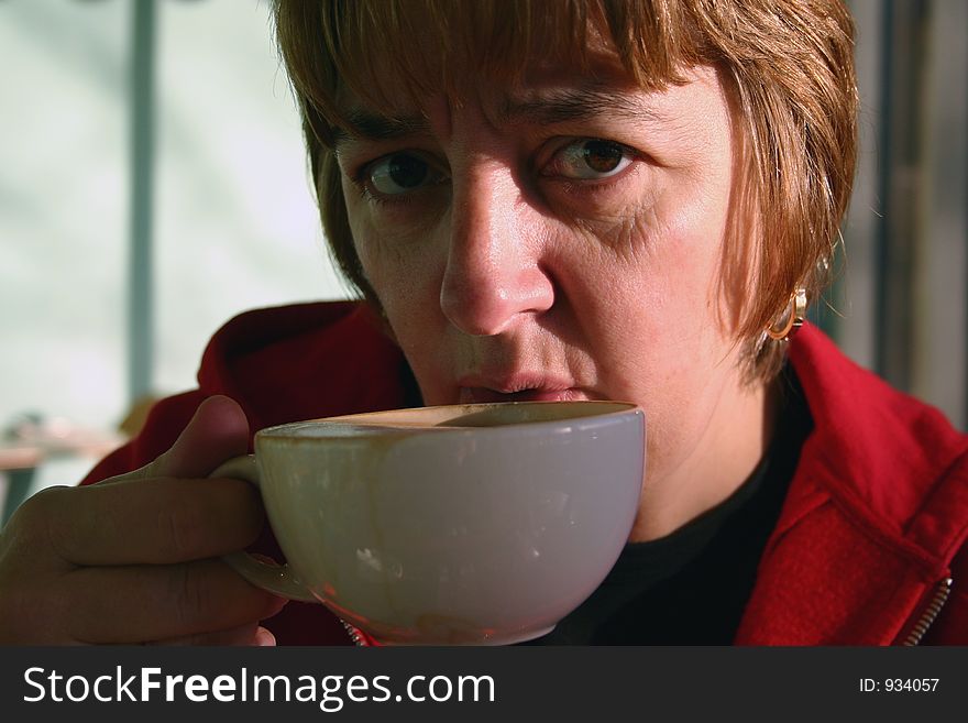 Female drinking coffee from large white cup. Female drinking coffee from large white cup