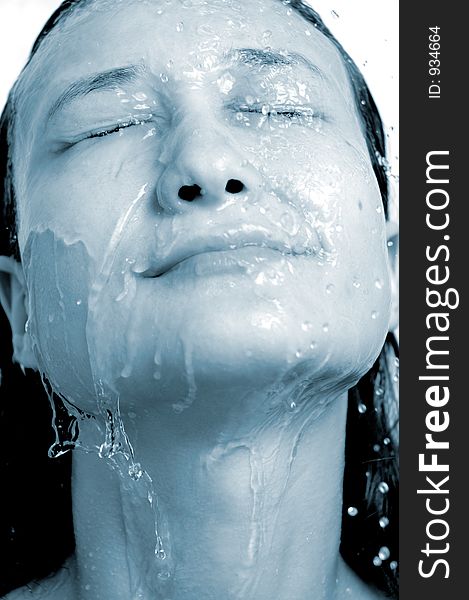 Young woman face under shower feminine hygiene concept blue sepia. Young woman face under shower feminine hygiene concept blue sepia