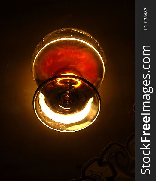 Glass of brandy on the glass dark background