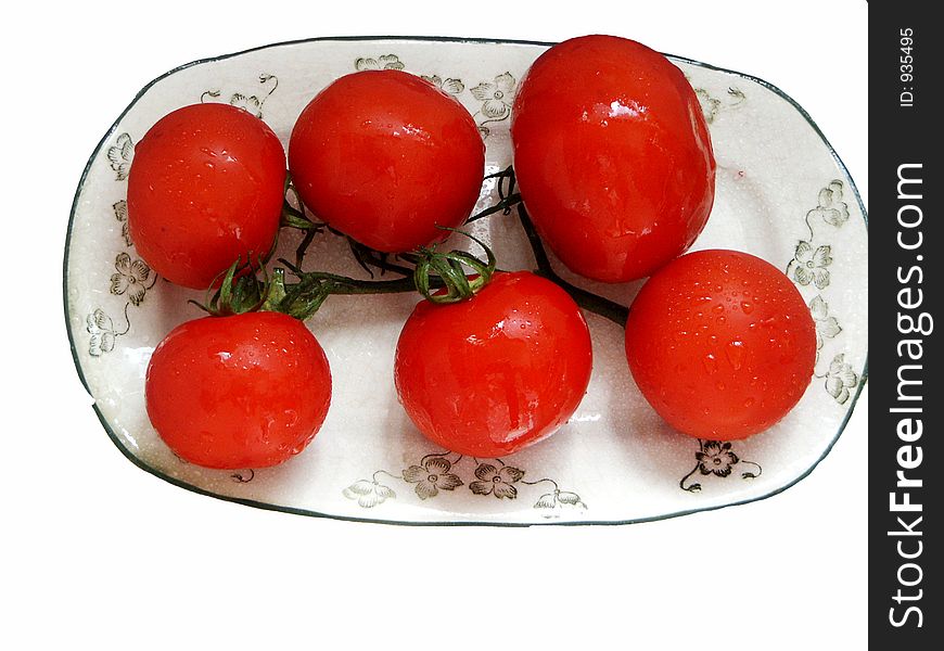 Cluster of red tomatoes on a plate with a green ornament. Cluster of red tomatoes on a plate with a green ornament