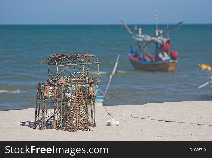 Lobster pot and local fishing boat on a sandy Thai beach. Lobster pot and local fishing boat on a sandy Thai beach