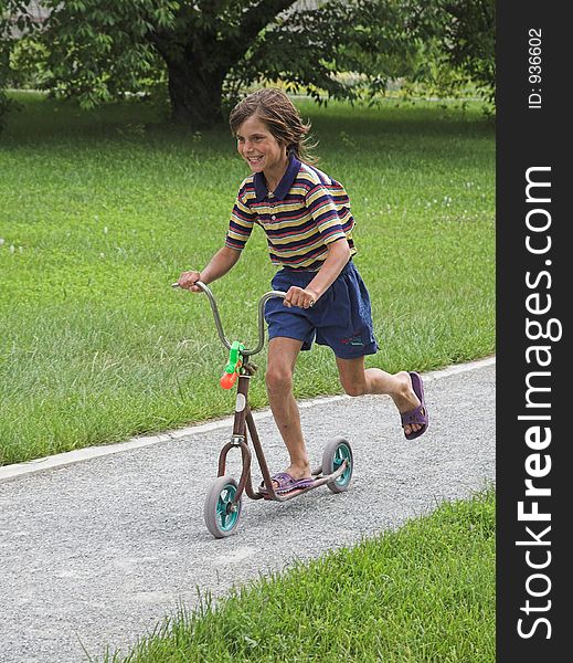 Merry boy in the scooter on summer