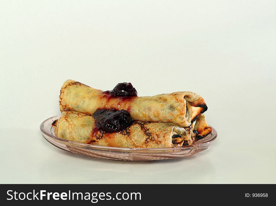 Rolled Pancakes With Strawberry Jam On A Glass Plate