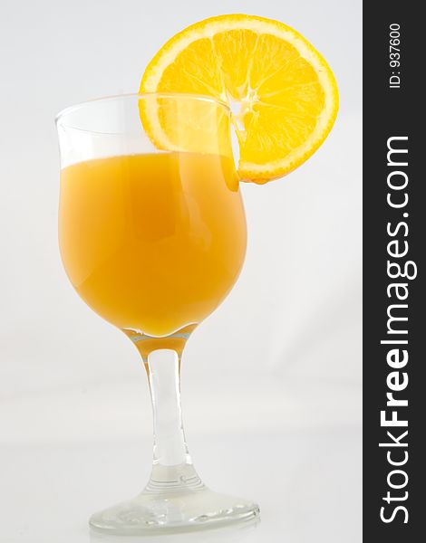 Glass of orange nectar with orange slice isolated on white background