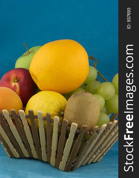 Small basket full of fruits on blue. Small basket full of fruits on blue