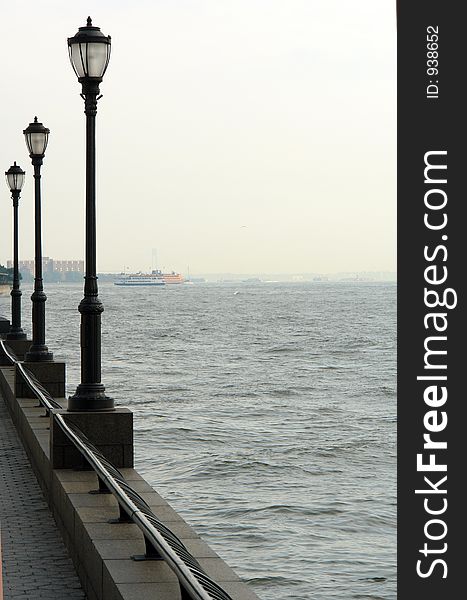 Along the esplanade in battery park with ferry in the background. Along the esplanade in battery park with ferry in the background