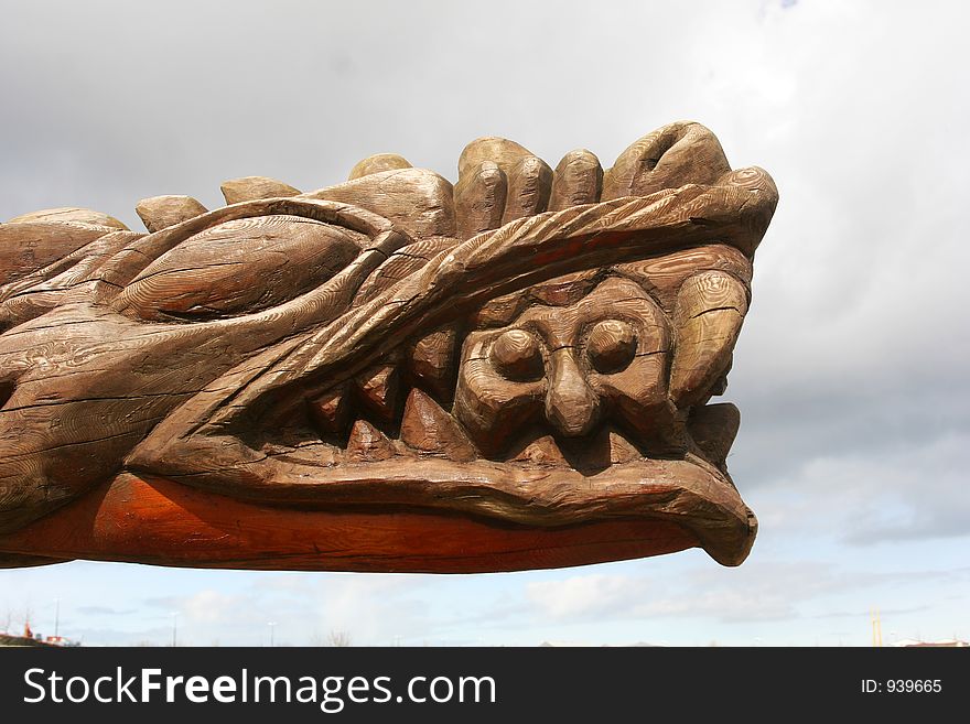 A Big carved head of a dragon with a man in its jaws