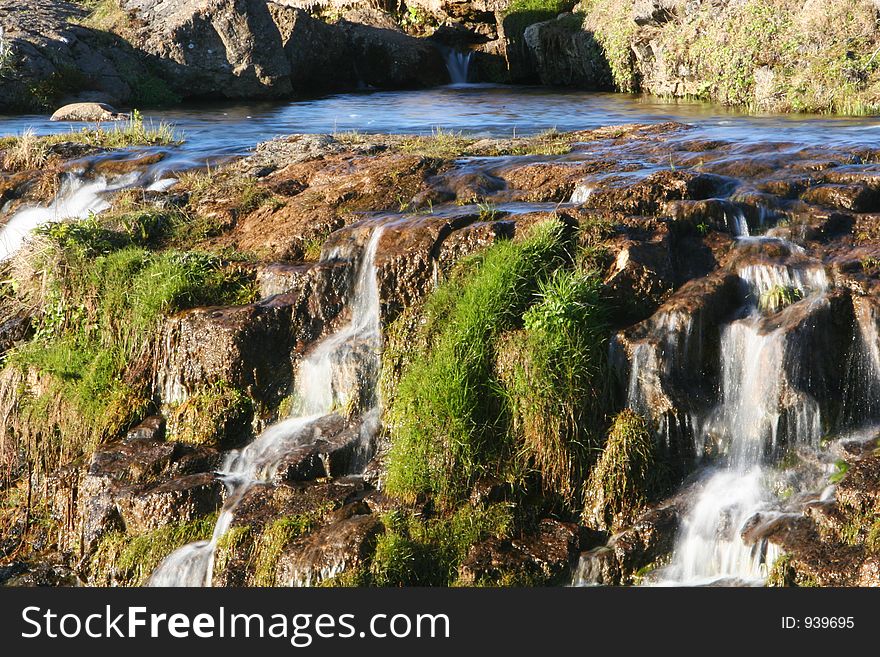 Photograph of small river, flowing, waterfalls, lush green vegetation and genuine tranquil athmosphere. Photograph of small river, flowing, waterfalls, lush green vegetation and genuine tranquil athmosphere