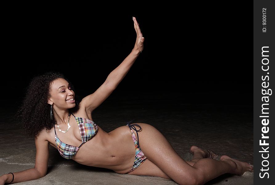 Young woman on the beach at night and waving