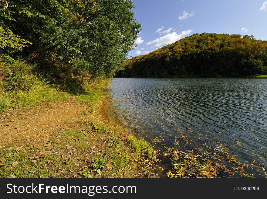 Mountain lake in early autumn surrounded by forest. Mountain lake in early autumn surrounded by forest