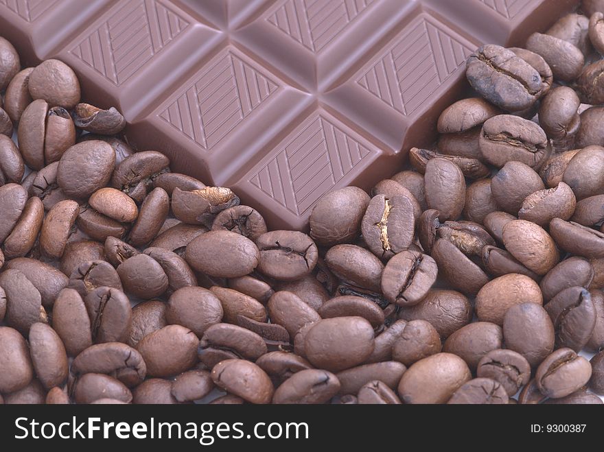Chocolate on the coffee beans background. Selective focus. Chocolate on the coffee beans background. Selective focus