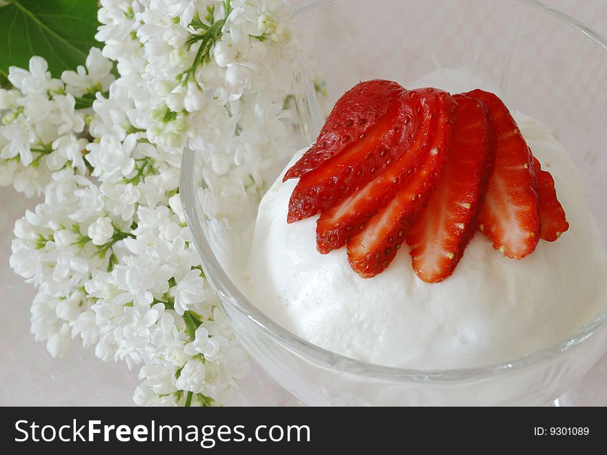 Milk frozen decorated by a strawberry and branch of white lilac