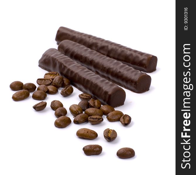 Chocolate bars and coffee beans on white background