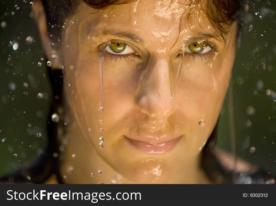 A splash of water in womans face,  closeup