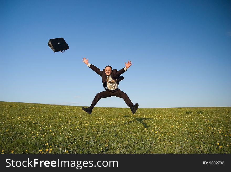 Jumping Businessman in meadow - green grass and blue sky. Jumping Businessman in meadow - green grass and blue sky