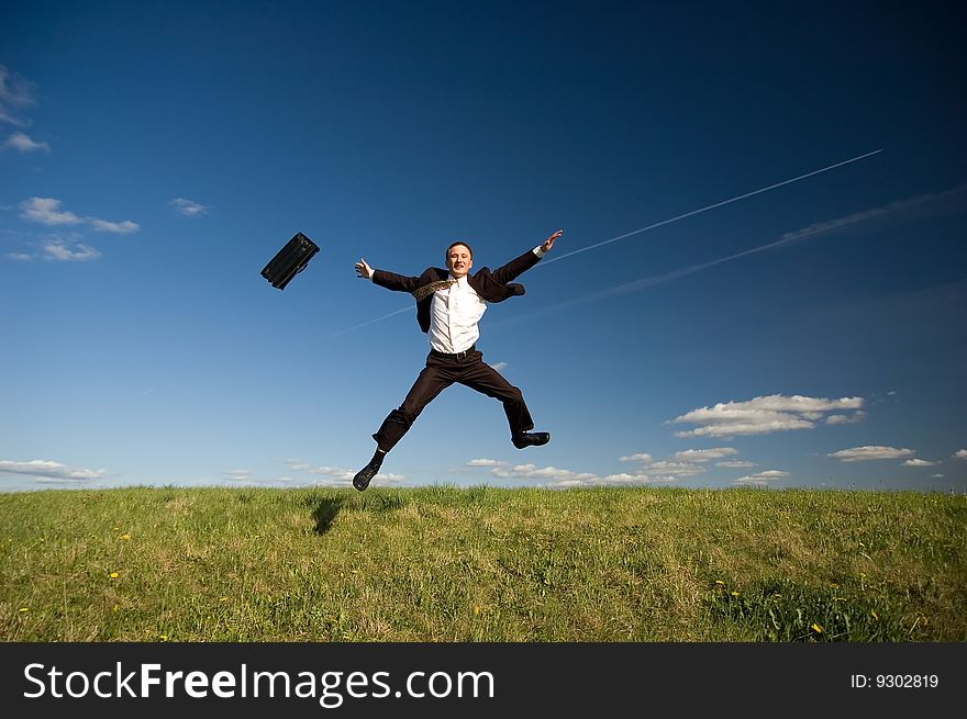 Jumping Businessman in meadow - green grass and blue sky. Jumping Businessman in meadow - green grass and blue sky