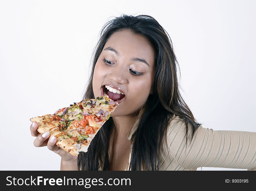 Sweet and pretty girl eating pizza slice and posing