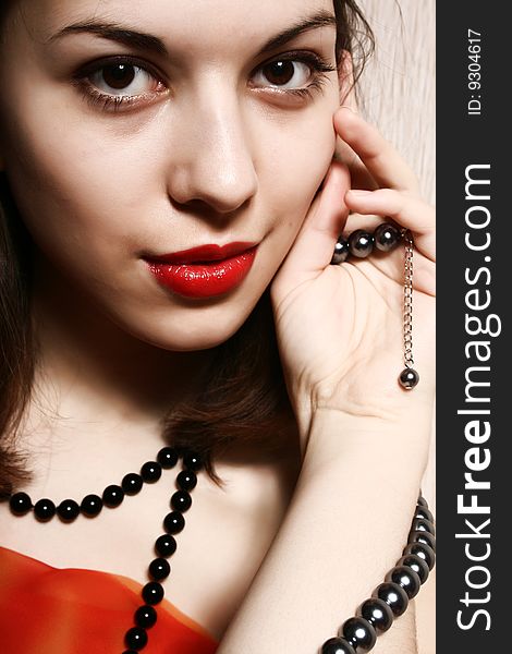 Portrait of the beautiful girl with red lips and a beads. Portrait of the beautiful girl with red lips and a beads.