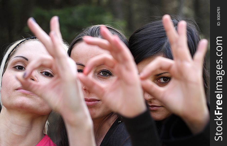 Girls looking through their crossed  fingers