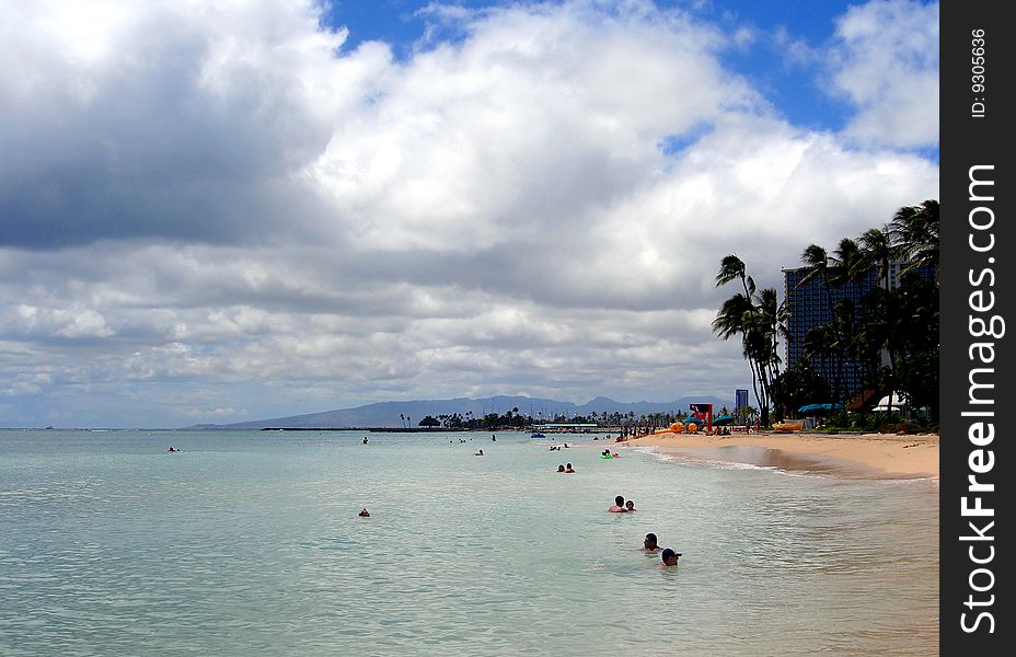 Tourists enjoying the cooling waters of Waikiki Beach, Hawaii