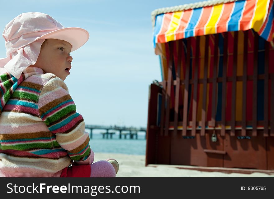 Baby with roofed wicker beach chair. Baby with roofed wicker beach chair