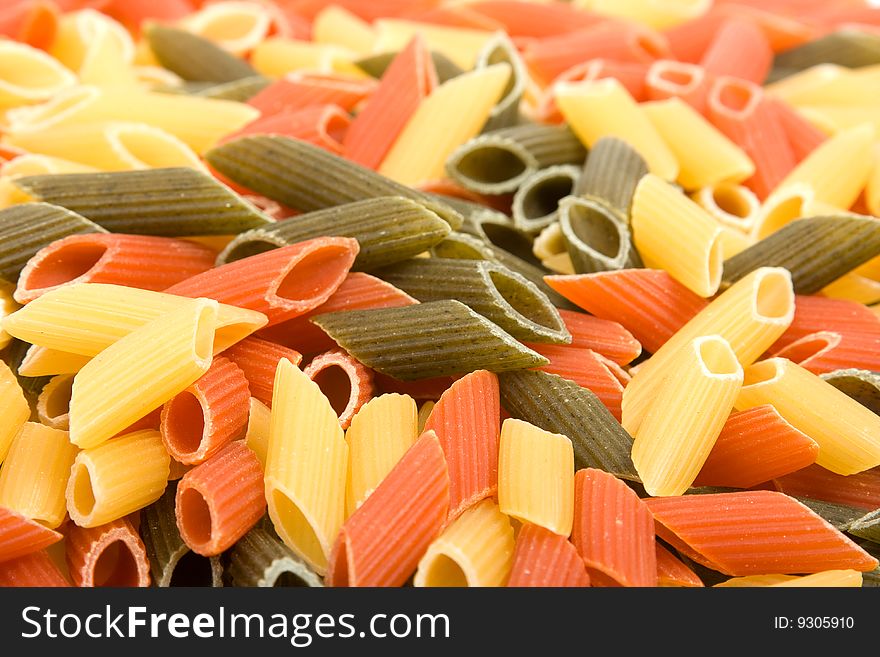 Colored raw penne as background.