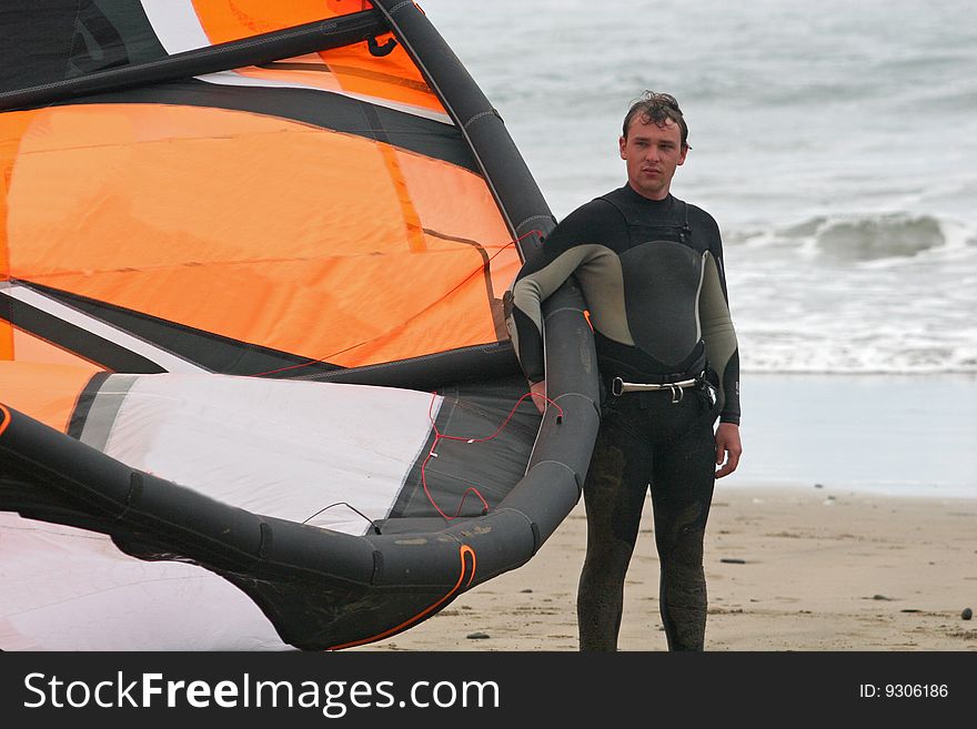 Kitesurfer holding kite on beach